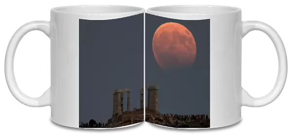 Temple of Poseidon is seen as the moon is partially covered by the Earths shadow during