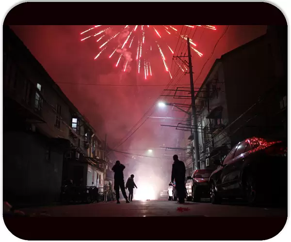 Men light up fireworks as residents celebrate the start of the Chinese New Year in