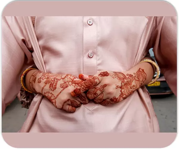 The hands of a girl, adorned with henna patterns, as she arms around her father while