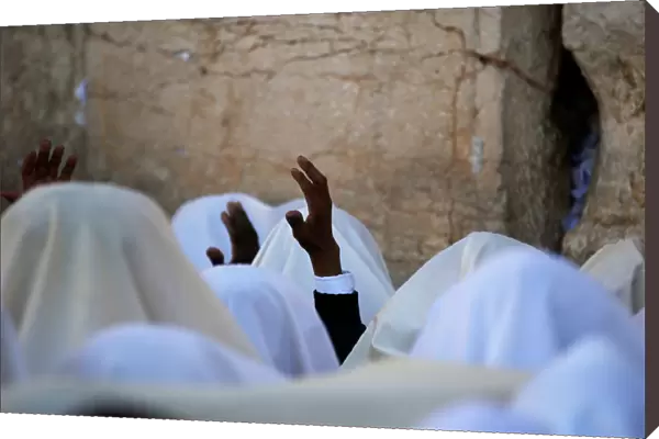 Jewish worshippers wrapped in prayer shawls participate in the priestly blessing prayer