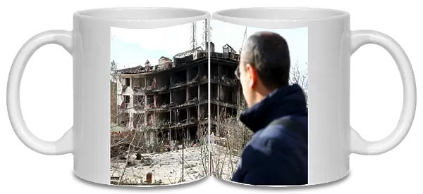 A man looks at a destroyed police station in Cinar in the southeastern city of Diyarbakir