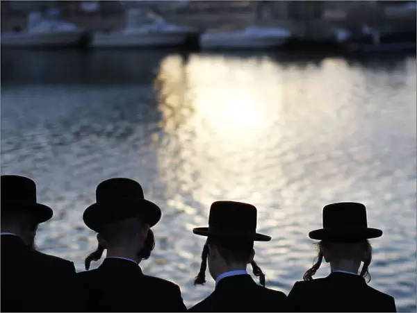 Ultra-Orthodox Jewish men perform the Tashlich ritual on the shore of the Mediterranean