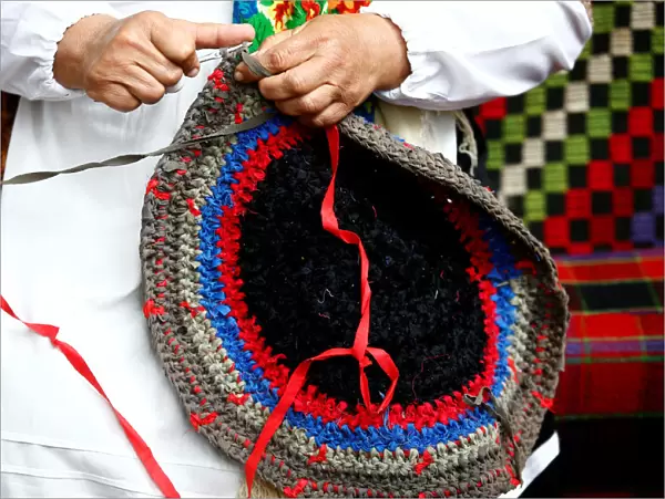 A woman knits a rug as she takes part in Beraginya festival of folklore art in the town