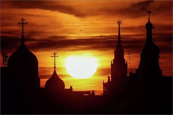 The sun sets over domes of the Andreevsky Monastery and the main building of the