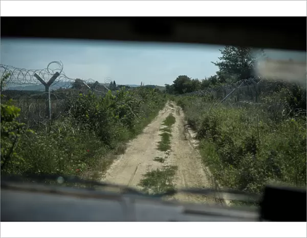 A wire fence is seen from an army vehicle as Macedonian soldiers patrol at the