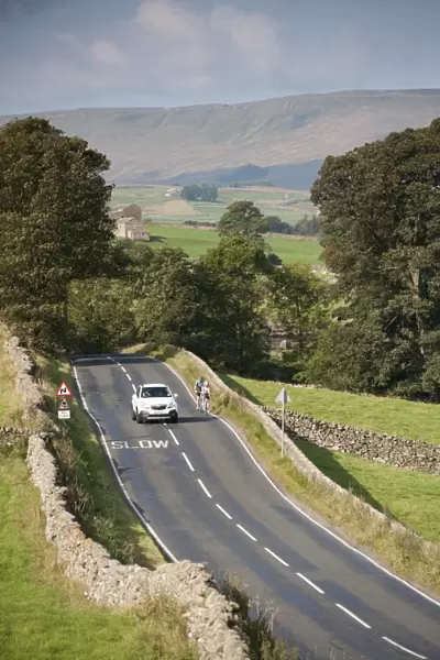 Country road with car passing cyclists, near Hawes, Wensleydale, Yorkshire Dales N. P