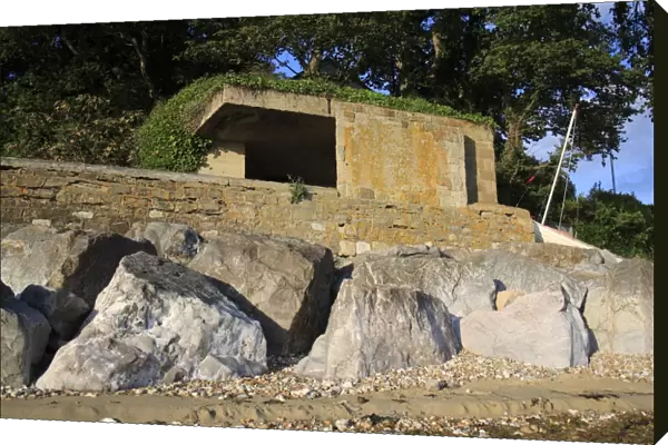 World War Two gun emplacement and riprap boulders at edge of beach, Bembridge, Isle of Wight, England, june