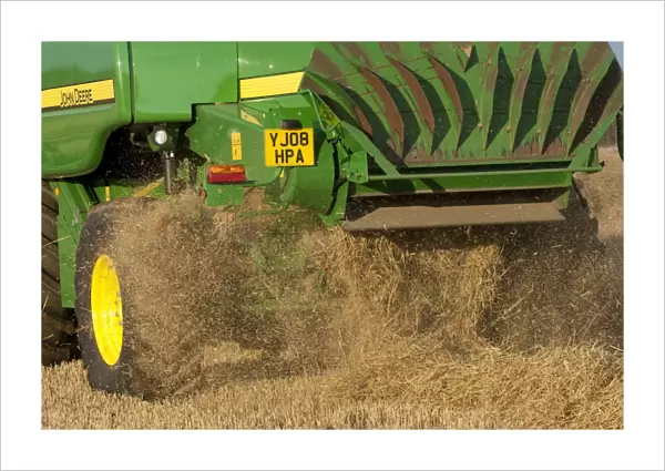 John Deere combine harvester, harvesting Barley (Hordeum vulgare) crop, discharging chaff and straw waste from back