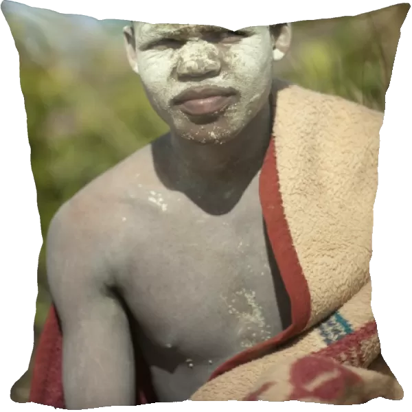AmaPondo (Xhosa) boy wrapped in rugs with white clay (I-Futa) on face, after being circumcised (uku-Lukwa)