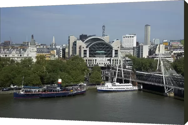 View from London Eye of city river with boats and Charing Cross railway station, Hungerford Bridge, River Thames