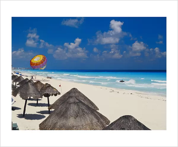 06. Mexico, Cancun, Sunshades along beach with parachute in background