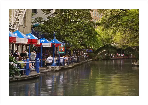 Tourists dining in outdoor cafe on the famous River Walk along the San Antonio River