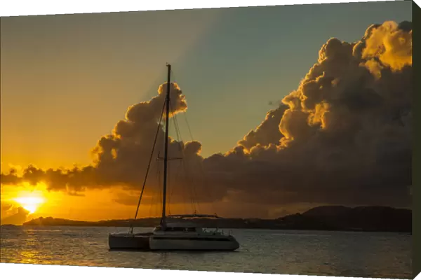 Caribbean, USA Virgin Islands. Sailboat moored in Frank Bay at sunset. Credit as