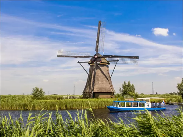 Canal tour boat and windmill in Unesco World Heritage Site, Kinderdijk, Holland