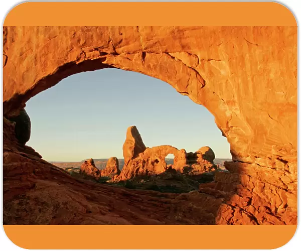USA, Utah, Arches National Park. Turret arch seen through the North Window at sunrise