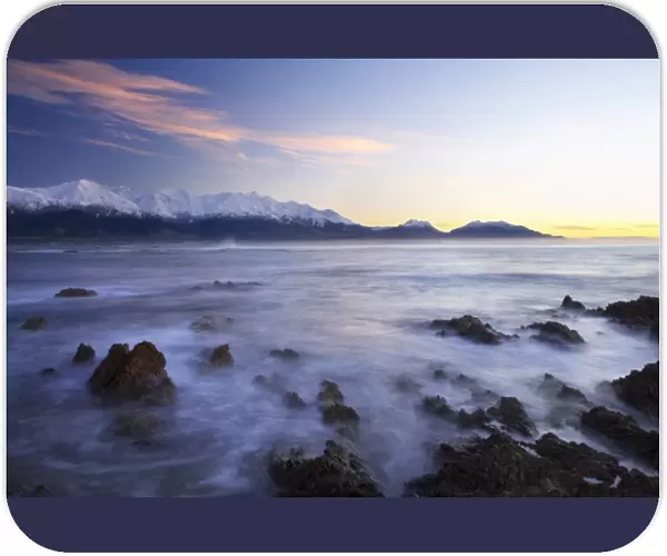 New Zealand, South Island, Kaikoura, Waves on Rocks and Seaward Kaikoura Range at Dawn