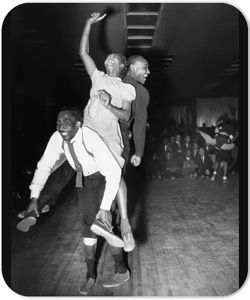 Three dancers dancing the Harlem conga, a blend of the lindy hop, conga and the Australian kangaroo hop, at a dance hall in Harlem, New York, 1941
