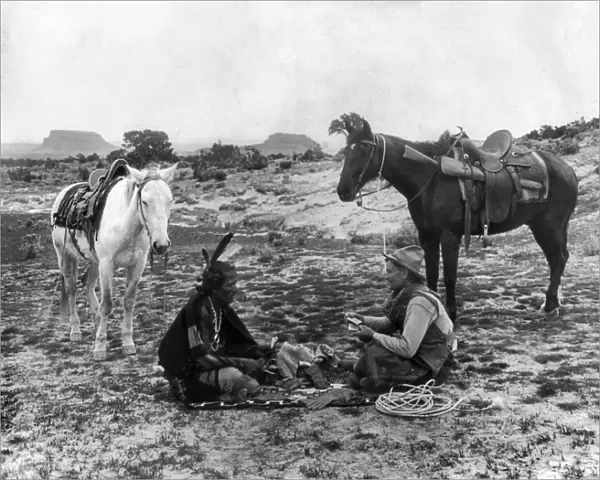 PLAYING CARDS, c1915. A cowboy and a Native American man seated on a blanket