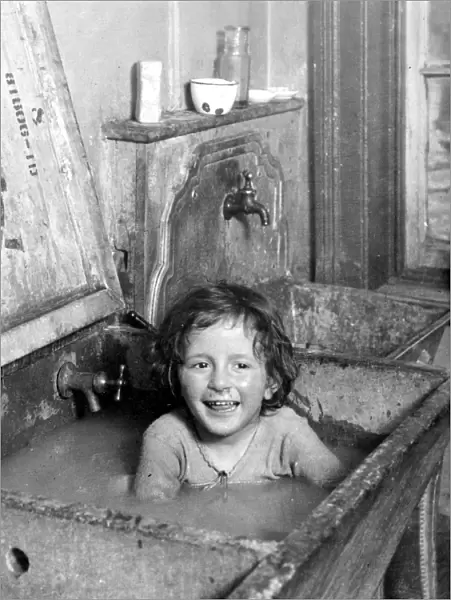 NYC: TENEMENT LIFE, c1900. Bathing in the kitchen sink on the Lower East Side