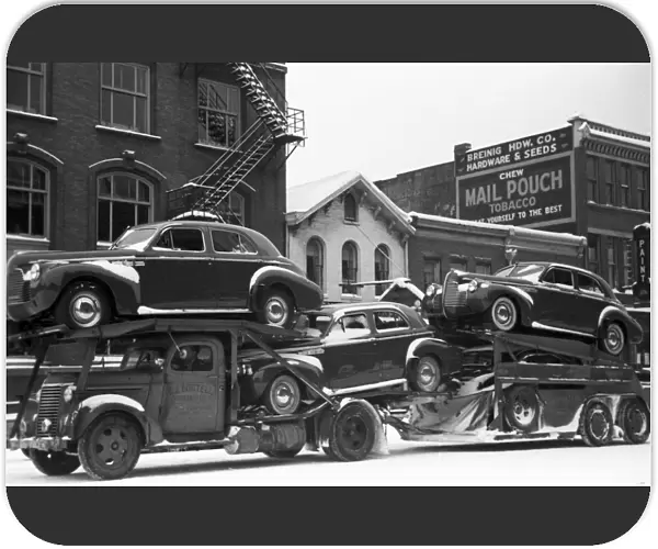 OHIO: AUTO TRANSPORT, 1940. A truck carrying automobiles through the streets of Chillicothe, Ohio. Photograph by Arthur Rothstein, February 1940