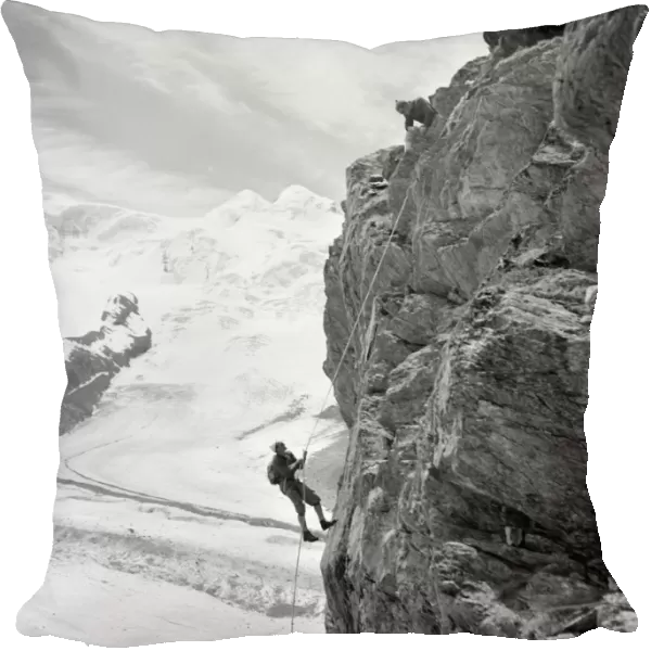ALPINE MOUNTAINEERS, 1954. Two mountain climbers on the side of a mountain at Zermatt