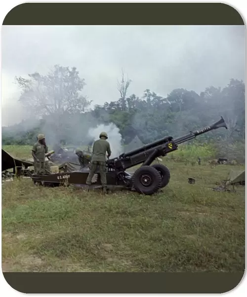 VIETNAM WAR, 1966. US Army soldiers firing an M102 howitzer in the direction of Viet Cong