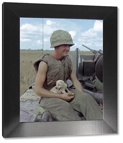 VIETNAM WAR, 1966. US Army soldier Jackie Coulter holding a dog that survived an