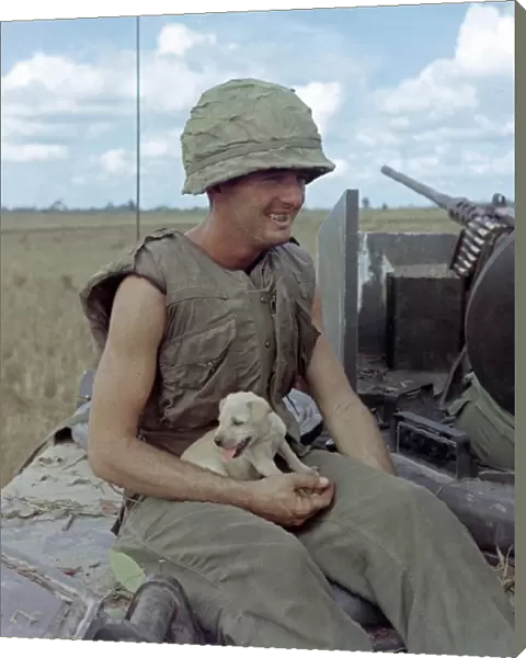 VIETNAM WAR, 1966. US Army soldier Jackie Coulter holding a dog that survived an
