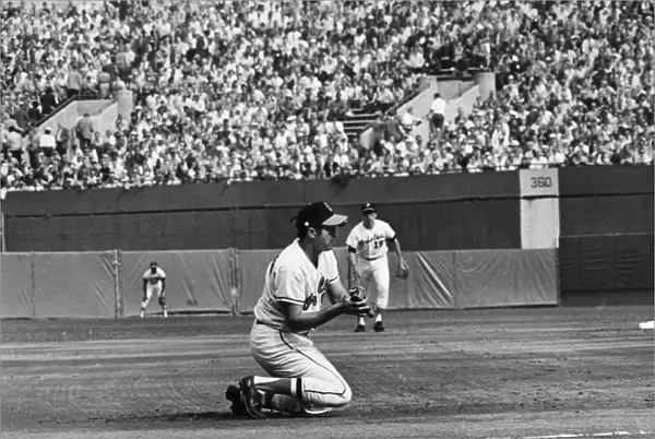 WORLD SERIES, 1970. Brooks Robinson, third baseman for the Baltimore Orioles, kneels to catch a ball hit by Johnny Bench of the Cincinnati Reds to end the top of the first inning of Game 3 of the 1970 World Series, at Memorial Stadium, Baltimore, Maryland, 13 October 1970