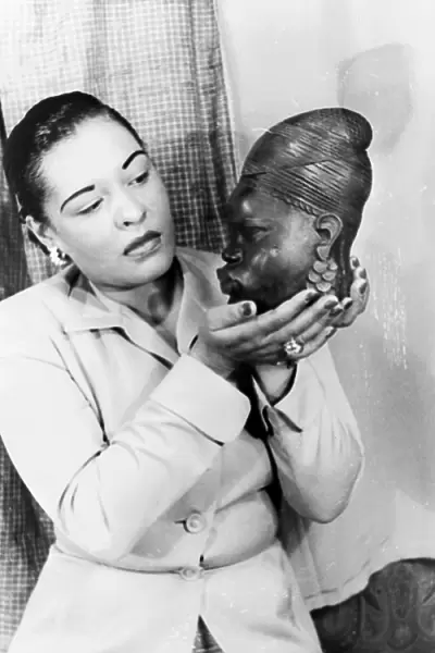BILLIE HOLIDAY (1915-1959). American jazz singer, holding an African sculpture. Photographed by Carl Van Vechten, 1949