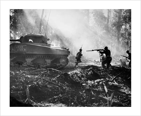 WORLD WAR II: BOUGAINVILLE. American soldiers advancing behind a tank on the Japanese-held island of Bougainville, October 1943