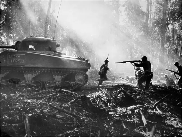 WORLD WAR II: BOUGAINVILLE. American soldiers advancing behind a tank on the Japanese-held island of Bougainville, October 1943