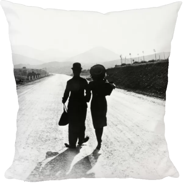 CHAPLIN: MODERN TIMES, 1936. Charlie Chaplin and Paulette Goddard in the final scene from the film, Modern Times, 1936