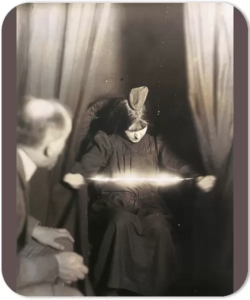 MEDIUM DURING SÔÇ░ANCE, 1912. The medium Eva C. with a materialization on her head and a luminous apparition between her hands. Manipulated photograph taken during as ance, by German photographer Albert von Schrenk-Notzing, 17 May 1912