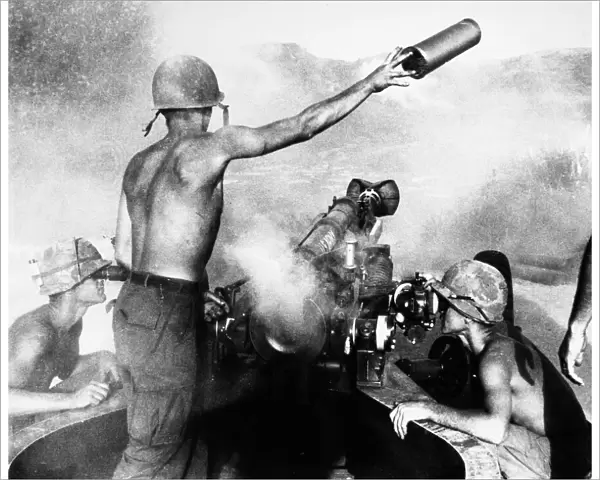VIETNAM WAR: ARTILLERY. An American artilleryman discards a spent shell casing, ejected from a 105mm Howitzer in the central highlands of South Vietnam, March 1967