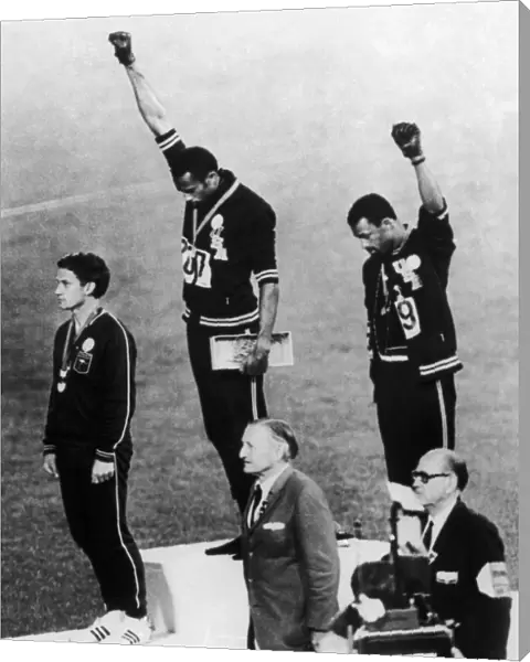 OLYMPIC GAMES, 1968. American runners Tommie Smith (center) and John Carlos (right) showing the Black Power salute during the medal ceremonies at the Olympic Games in Mexico City. Australian Peter Norman (left) wears an OPHR badge in solidarity. Photograph, 1968