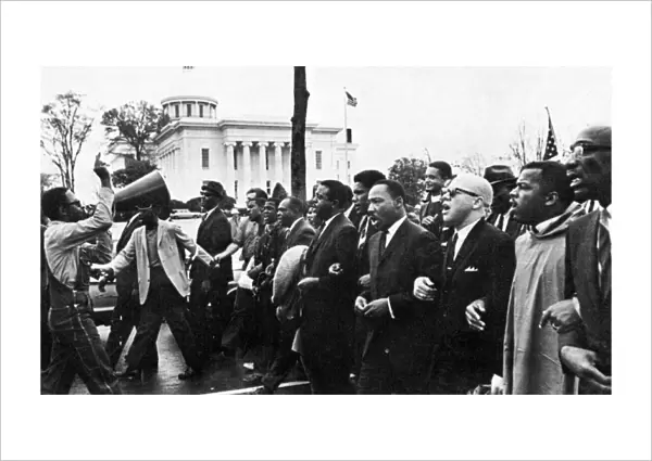 MARTIN LUTHER KING, JR. (1929-1968). American clergyman and reformer. Dr. King (fourth from right) leading the march from Selma on the state capitol at Montgomery, Alabama, 25 March 1965
