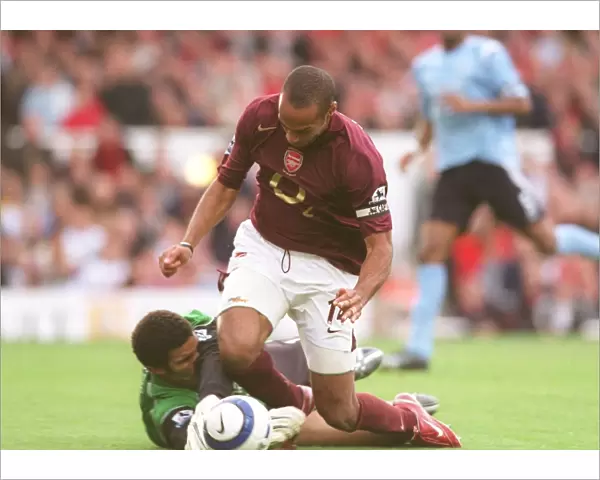Thierry Henry (Arsenal) is tripped by David James (Man City) for the Arsenal penalty