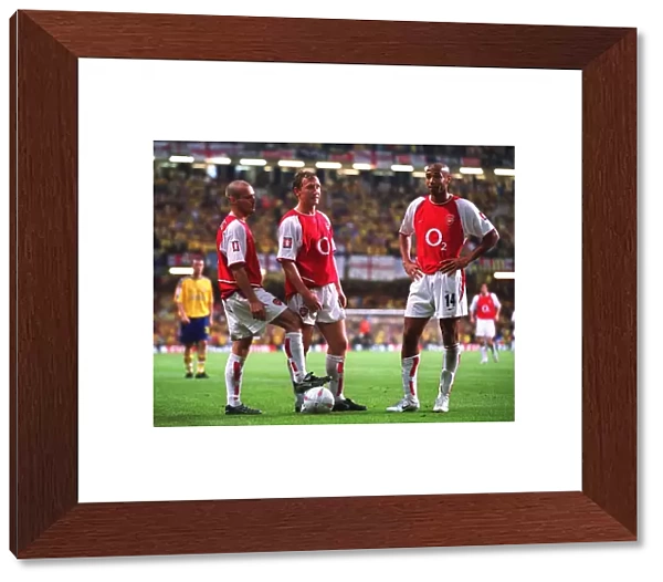 Freddie Ljungberg, ray Parlour and Thierry Henry (Arsenal) stand over the ball before taking a free