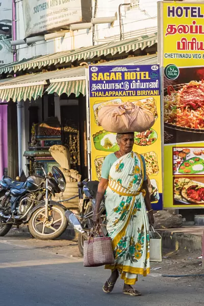 A shopper carrying a load on her head at Mamallapuram in Tamil Nadu, India
