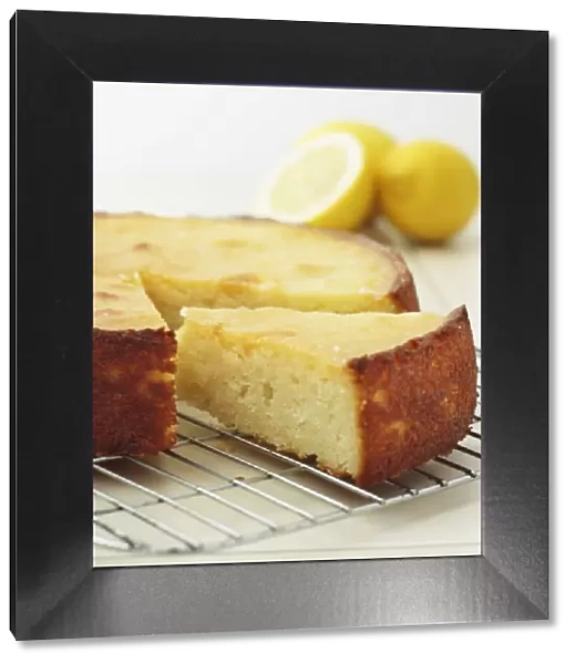 Slice of sticky lemon cake on cooling rack, close-up