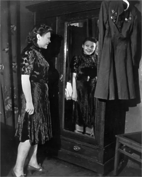 Nina lobkovskaya in war and peace, like all young girls, nina loves pretty clothes, here she is trying on a dress during a shopping trip, if it were not for her uniform with its decorations hanging nearby, no one would guess that she has been through the war, 1940s