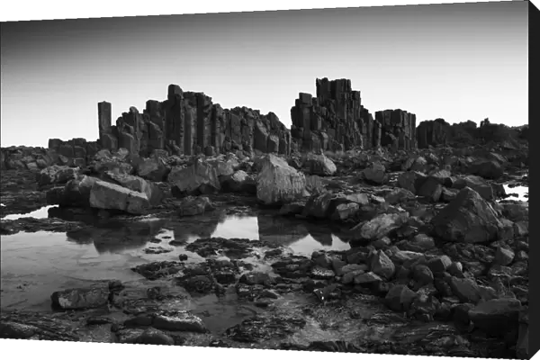 Monochrome, Dramatic coastal basalt columns rock formations at sunset at the disused