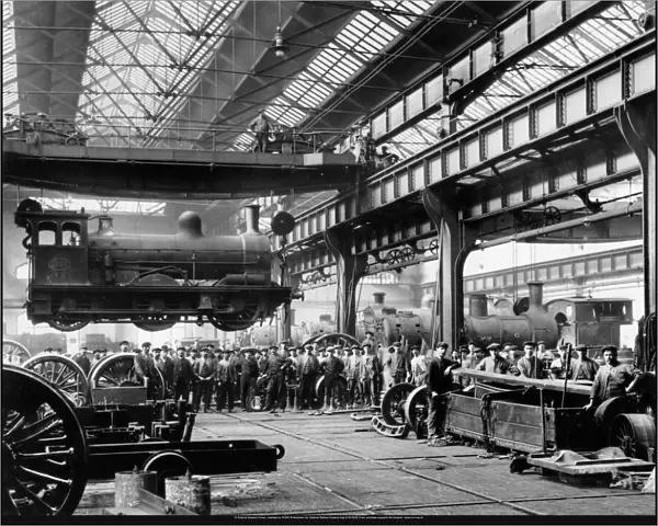 Crowds watching a suspended locomotive at the North Eastern Railways Gateshead Works