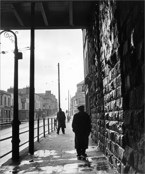 Tiger Bay; A man walking under a railway bridge in the dockland area of Cardiff