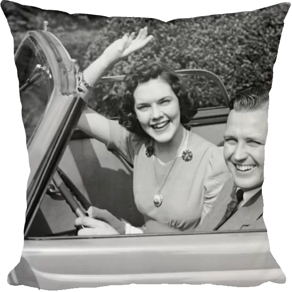 Man driving car and woman waving