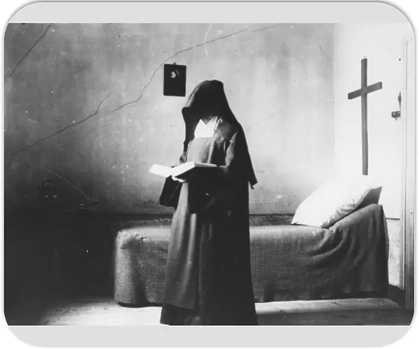 Nuns Cell. 1904: A Carmelite nun reading a book in the cell furnished only with a bed