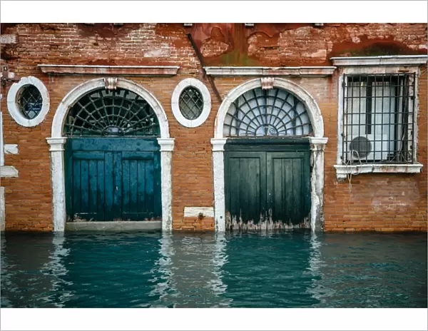 Half sunken doors of townouse by the canal in Venice, Italy