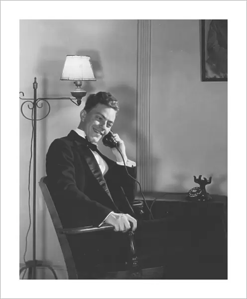 Man in Dinner Suit Sitting Indoors, Talking on Telephone