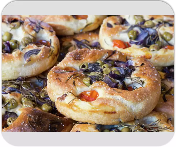 Focaccia, Italian flat bread made from yeast yeast dough with herbs, tomatoes and olives